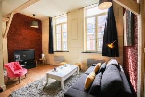 a living room with a couch and a tv at Old Lille charming duplex apartment in Lille
