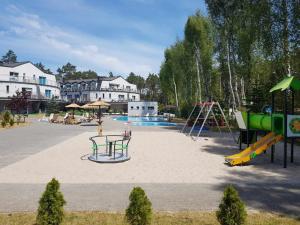 an empty playground with a slide and a swing set at Romantyczny Apartament HAPPY 16 BASEN & KORT TENISOWY, OCHRONA 24 h - dla maksymalnie 6 osób in Pobierowo