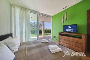 un soggiorno con TV e parete verde di Villa Madabà - Immobiliare Azzurra a Bardolino