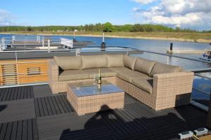 Hausboot Seensucht في Klitten: أريكة وطاولة على سطح قارب