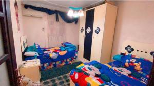 شقه فندقيه الترا سوبر لوكس بارقي مناطق اسيوط في أسيوط: غرفة نوم للأطفال مع سريرين مع قطة سلام