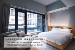a bedroom with a bed and a large window at Drizzle Inn in Keelung