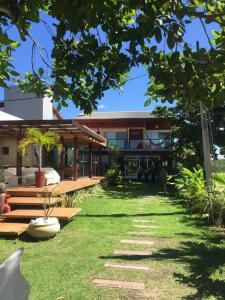 una casa con un patio de hierba delante de ella en Casa de Praia - Toquinho, Piscina, Área de Laser., en Ipojuca