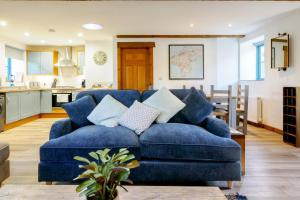 un sofá azul en una sala de estar con cocina en Lamorna, en Mawnan Smith