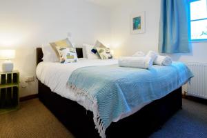 1 dormitorio con 1 cama grande y toallas. en Lamorna, en Mawnan Smith