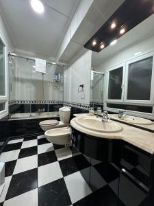 uma casa de banho com piso em xadrez preto e branco em Fantástico apartamento en el centro de Bilbao em Bilbao