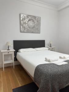 um quarto com uma grande cama branca e duas mesas em Fantástico apartamento en el centro de Bilbao em Bilbao