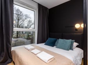 a bedroom with a bed with a large window at Quercus Deluxe Studio in Gdańsk