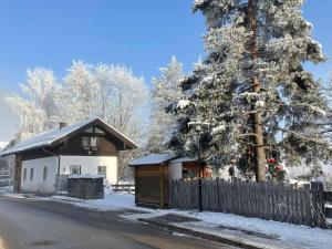 a small house with a fence next to a tree at 11er Häusl in Flachau