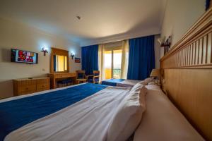 una camera da letto con un grande letto con una coperta blu di Regency Pyramids Hotel a Il Cairo