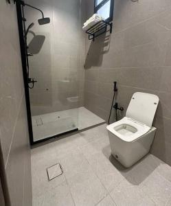 a bathroom with a toilet and a shower at تربل فور سويت - شقة في فيلا in Al Başar