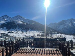 een uitzicht op een met sneeuw bedekte berg met een straatlicht bij Monolocale con terrazzo e vista spettacolare sui monti in Sestriere