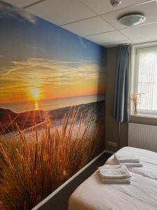 ein Schlafzimmer mit einem Gemälde eines Strandes in der Unterkunft Bed and Breakfast De Zeehoeve in Harlingen
