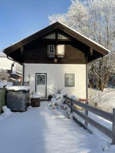 a house covered in snow with a fence at 11er Häusl in Flachau