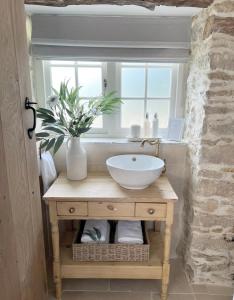 baño con lavabo y ventana en Greystone Guesthouse en Titchmarsh