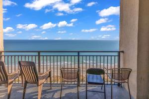 a balcony with chairs and a view of the beach at Scenic Views from the balcony at Ocean Forest Plaza Condos in Myrtle Beach