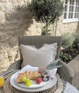 einen Tisch mit einem Teller Essen auf einem Korbstuhl in der Unterkunft Greystone Guesthouse in Titchmarsh