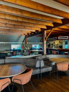 a restaurant with wooden ceilings and tables and chairs at Bed and Breakfast De Zeehoeve in Harlingen