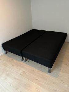 a black bed in a corner of a room at Great View Apartments 3 in Aalborg