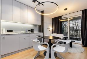 a kitchen and dining room with a table and chairs at Quercus Deluxe Studio in Gdańsk