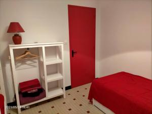 1 dormitorio con puerta roja y cama roja en Le Landrin, en Pénestin 5 fotos más