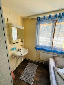 uma pequena casa de banho com um lavatório e uma janela em Restaurant & Hostel Hole in One em Randa