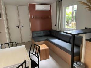 een kleine woonkamer met een bank en een tafel bij Magnifique mobilhome-2 sdb-Camping 5 étoiles in Biscarrosse