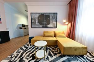 a small room with two beds and two tables at Leda Residence in Oradea