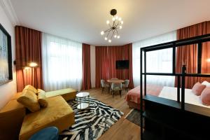 a hotel room with a bed and a couch at Leda Residence in Oradea