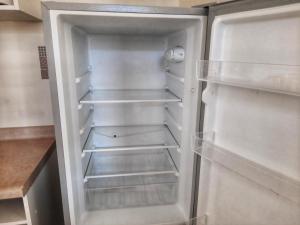 un réfrigérateur vide avec sa porte ouverte dans une cuisine dans l'établissement Departamento Centro de Temuco, à Temuco