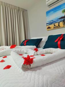 2 camas blancas grandes con flores rojas. en Pousada Waikiki Boutique, en Pipa