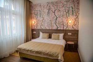 een slaapkamer met een bed met een roze muur bij Leda Residence in Oradea