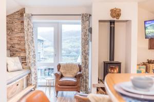 a living room with a chair and a fireplace at Romantic getaway, little two bed, two bath barn conversion with amazing views and parking in Ambleside