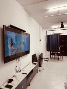 a living room with a large flat screen tv on the wall at Homestay Syahezzie fully aircond Netflix With Jacuzi in Ampang