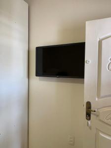 a door with a flat screen tv on a wall at Pousada Perola da Praia in Penha