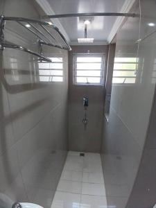 a bathroom with a shower stall and a window at One bedroom apartment. in Cape Town