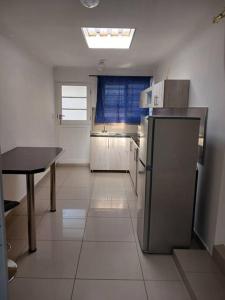 a kitchen with a refrigerator and a table in it at One bedroom apartment. in Cape Town