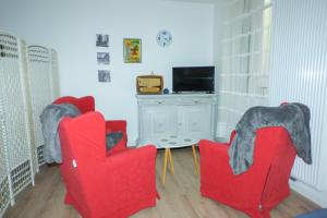 普拉茲德莫洛拉普雷斯特的住宿－Serra-Vernet del Roser，客厅配有2把红色椅子和电视