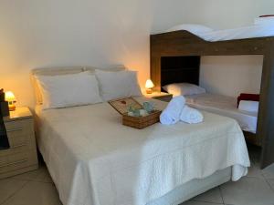 a bedroom with two beds with towels and a basket on a bed at Pousada Perola da Praia in Penha