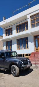 un jeep negro estacionado frente a un edificio en Lynx near Leh airport, en Leh