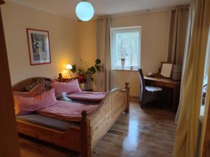 Schlafzimmer mit einem Bett mit rosa Kissen und einem Fenster in der Unterkunft Aparthotel & Wohnungen am Norderteich in Horn-Bad Meinberg