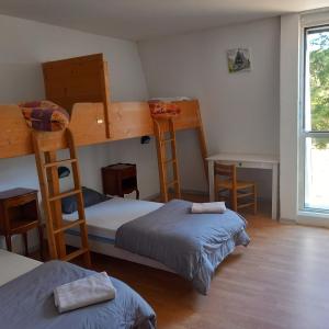 sypialnia z 2 łóżkami piętrowymi i biurkiem w obiekcie MONTLO RELAIS DES CERFS w mieście Cubières