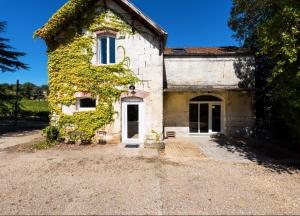 een oud stenen huis met klimop erop bij Chateau La Fontaine in Fronsac