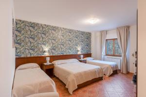 Habitación de hotel con 2 camas y un mural en la pared en Hotel Rasinus en Roccaraso