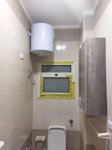 a bathroom with a toilet and a yellow window at Hurghada City Apartment 3 in Hurghada
