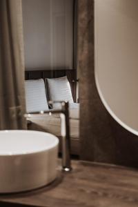 łazienka z kanapą, umywalką i lustrem w obiekcie kerii - adults boutique hotel w Saalbach Hinterglemm