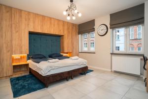 a bedroom with a large bed and a clock on the wall at TOTU HOME Chlebnicka Gdańsk Old Town in Gdańsk