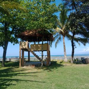 una torre salvavidas en la playa con una palmera en Karang Besi Losmen en Biha