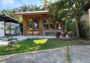 a house with a glass door and a yard at Smile Buffalo Resort สไมล์ รีสอร์ท in Ban Lum Phen