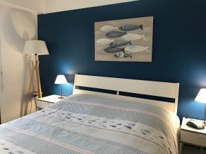 - une chambre dotée d'un lit avec un mur bleu dans l'établissement Ty Palud, à Névez